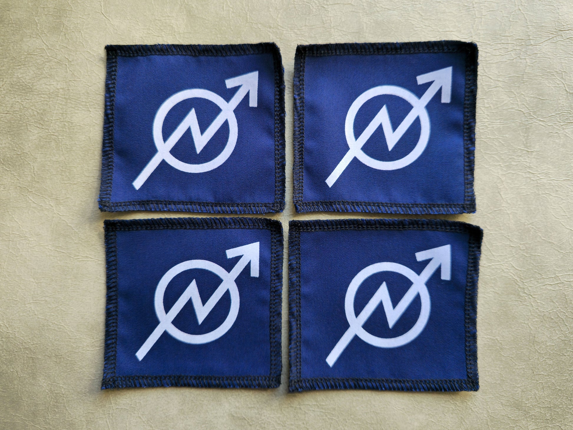 Blue handmade screen printed squat symbol patches shown as a coordinated set
