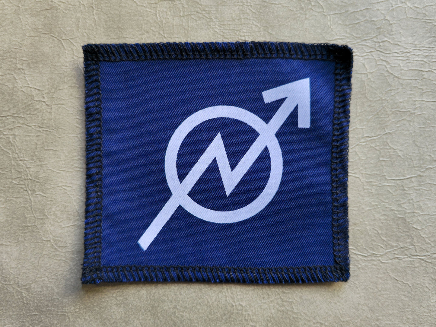 Blue handmade screen printed squat symbol patch with contrasting ink detail