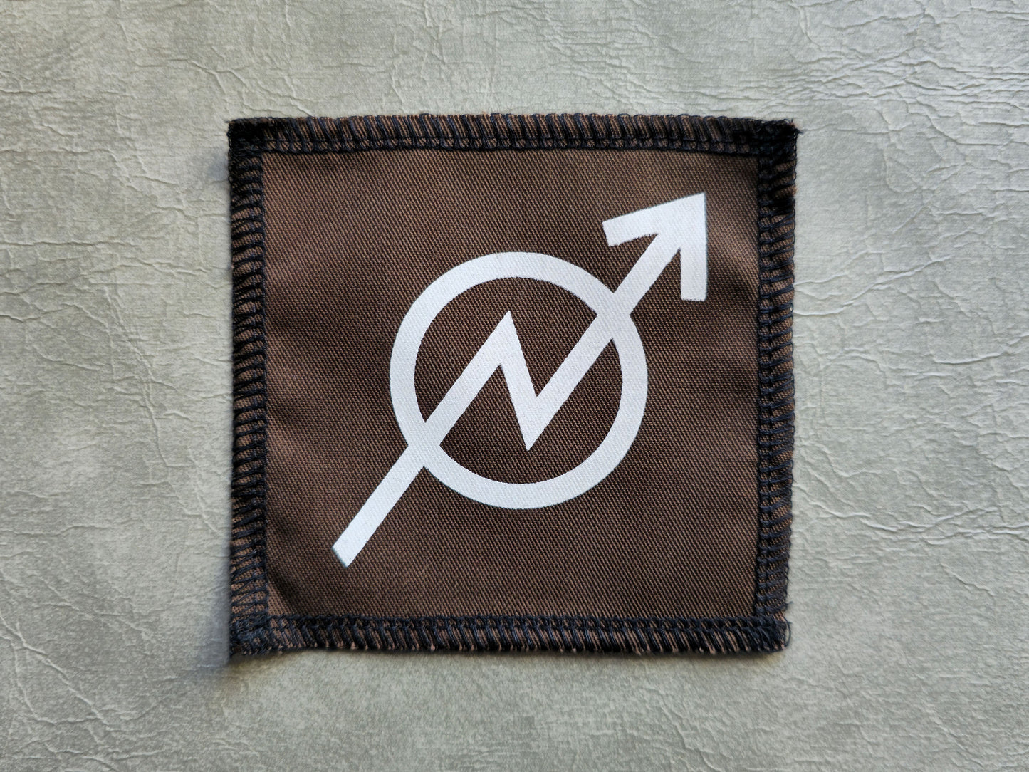 Brown handmade screen printed squat symbol patch with centered graphic print