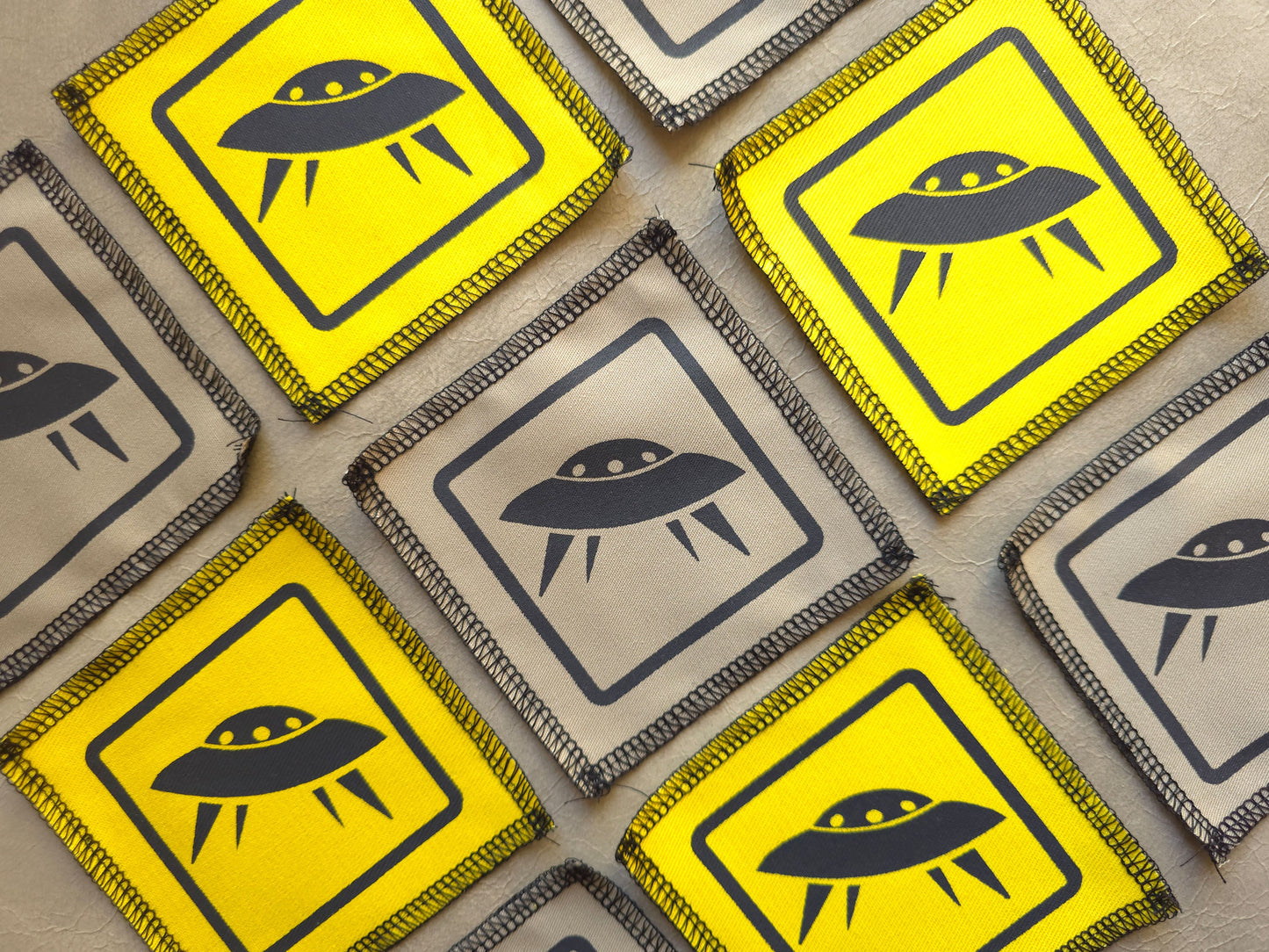 Multiple warning signs with UFO symbols on a textured surface