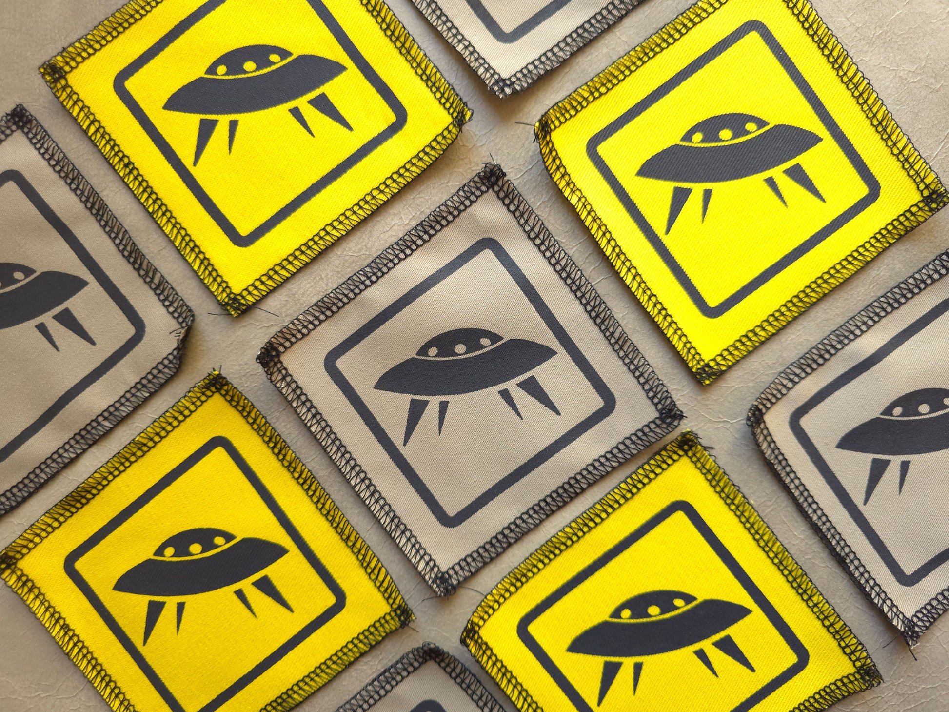 Multiple warning signs with UFO symbols on a textured surface