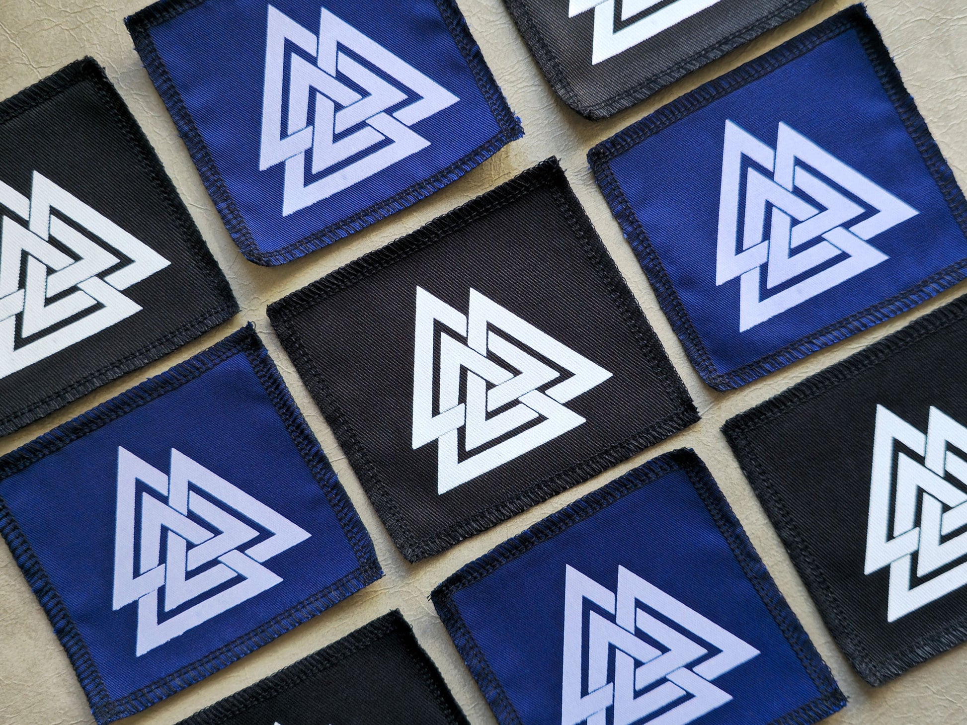 Angled view of handmade screen printed valknut symbol patch highlighting fabric texture and print detail