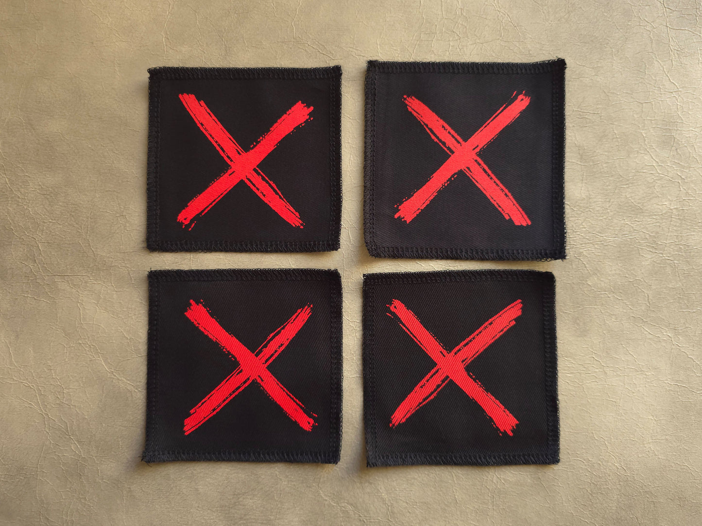 Black handmade screen printed x symbol patches displayed together