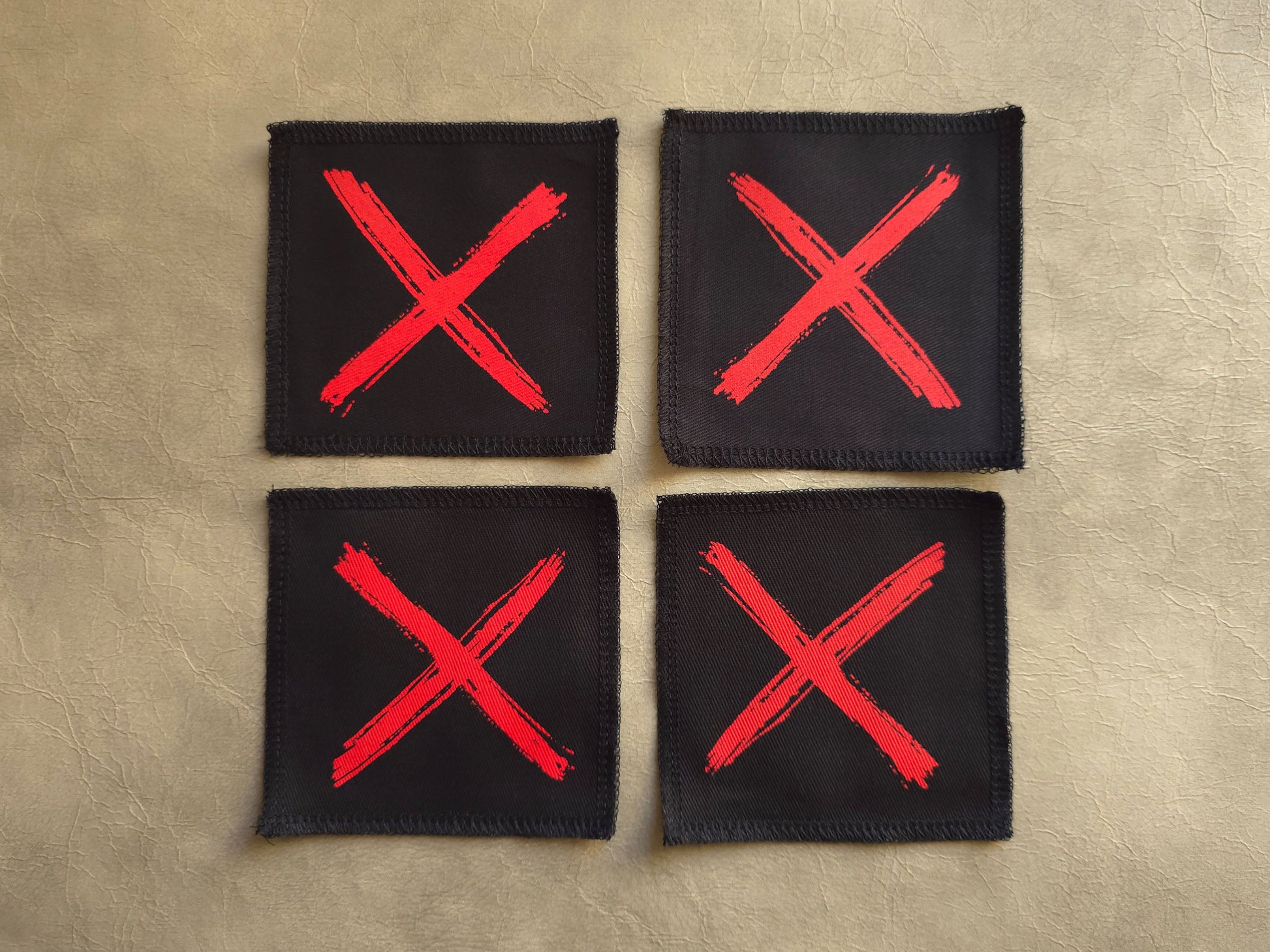 Black handmade screen printed x symbol patches displayed together