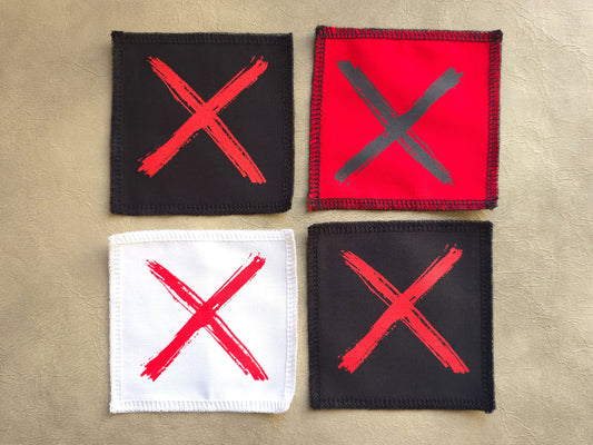 Handmade screen printed x symbol patch, front view showing detailed ink design on fabric