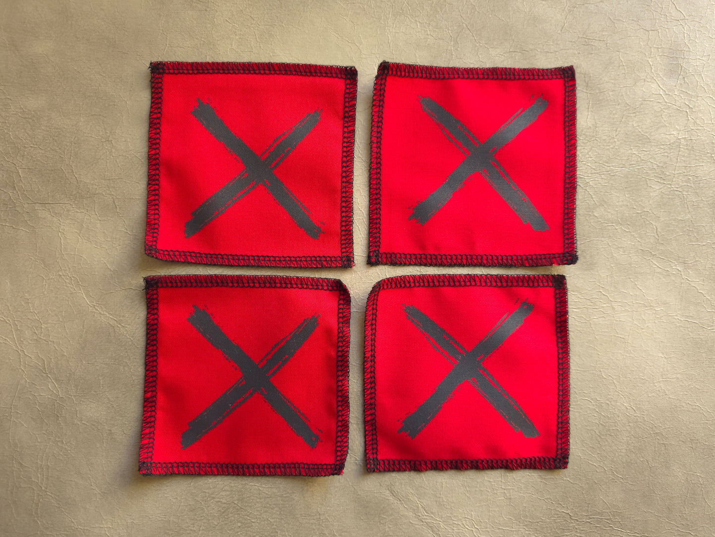 Red handmade screen printed x symbol patches arranged as a collection