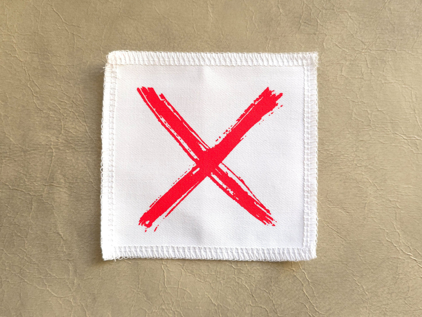 White handmade screen printed x symbol patch with crisp printed design